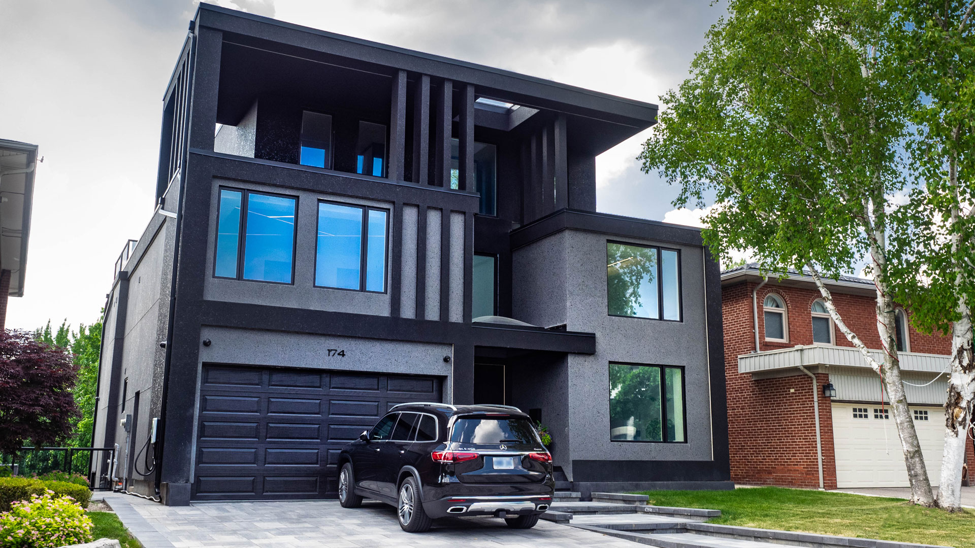 New home custom construction featuring a contemporary design of grey and black stucco, and custom exterior LED lighting