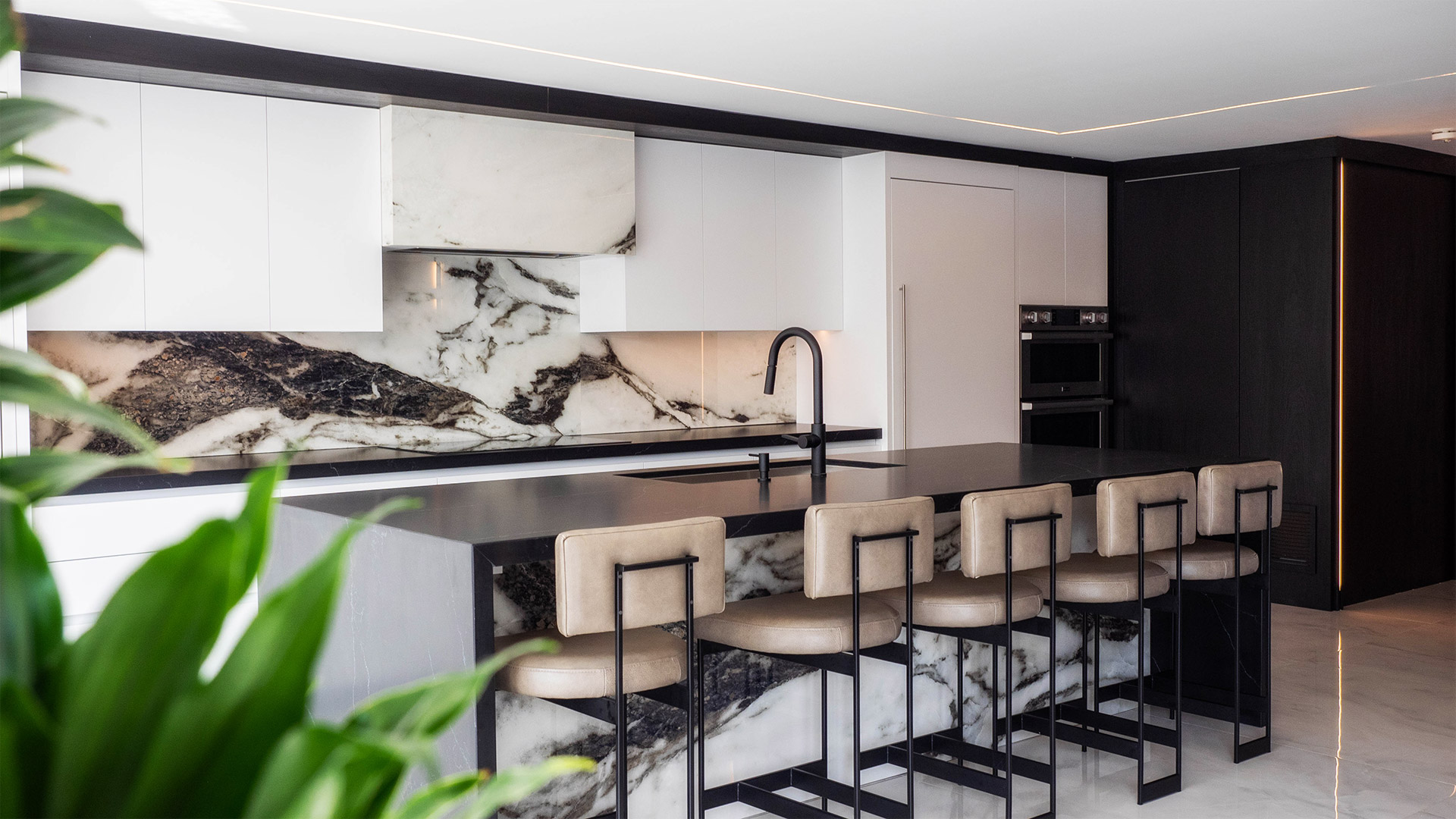 Custom Kitchen Construction with marble backsplash, white cabinetry, and large bar style island