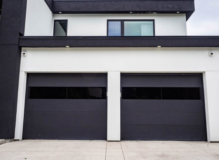 Double garage custom construction with matte black garage doors and an off white stucco finish
