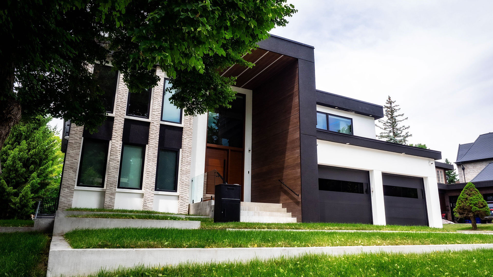 New home custom construction featuring a contemporary design of stone facades accented with white and black stucco